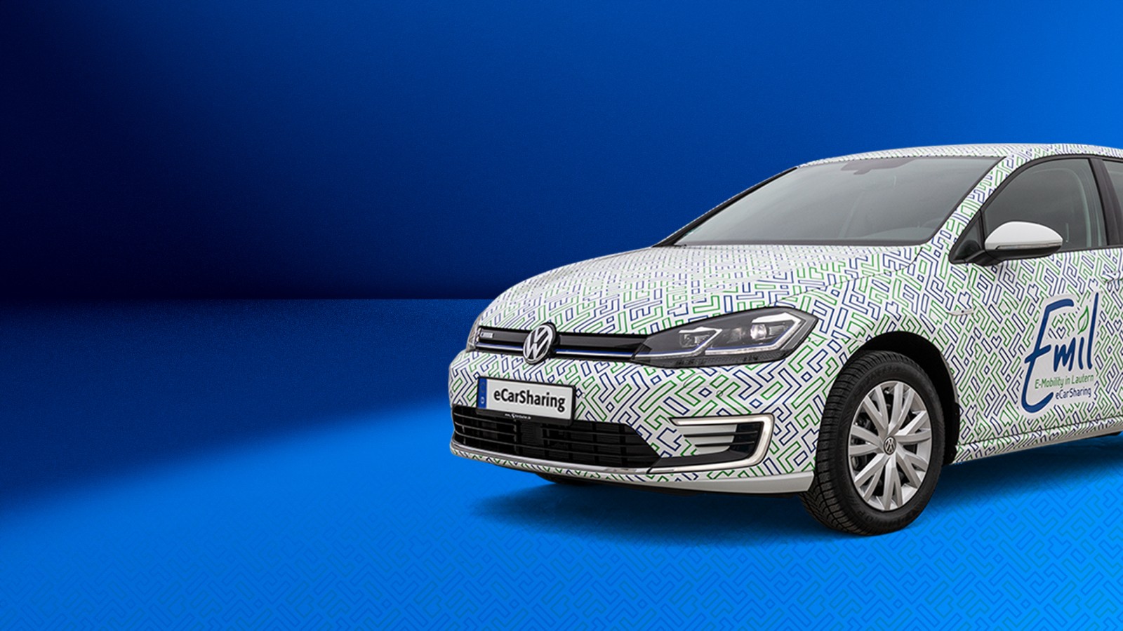 VW eGolf mit Emil eCarSharing-Branding auf blauem Hintergrund ragt rechts bis zu Hälfte ins Bild hinein. 